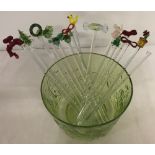 A collection of glass swizzle sticks with a green glass Villeroy & Boch bowl.