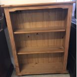 A modern pine bookcase with bun feet.