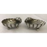 A pair of classical clam shell shaped silver salts with ball feet.