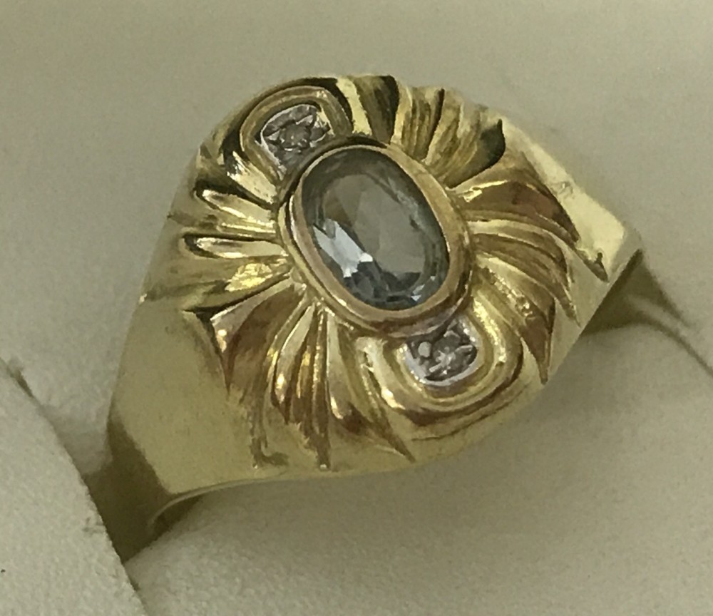 An 8ct (333) gold dress ring set with an oval aquamarine and 2 small diamonds.