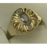 An 8ct (333) gold dress ring set with an oval aquamarine and 2 small diamonds.