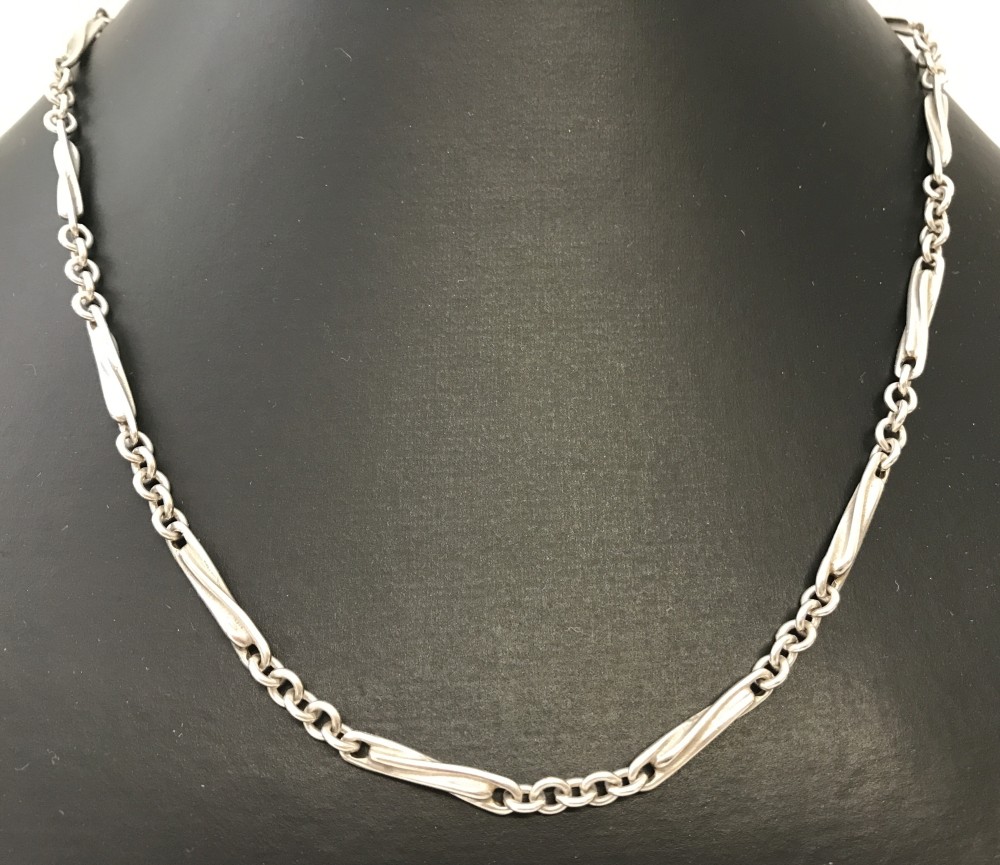 A 17 inch decorative silver necklace with twist and trace chain links.