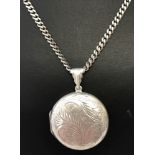 A round silver locket with engraved detail to front and back on a 16inch curb chain.