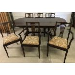 A vintage dark wood regency style draw leaf extending dining table with matching chairs.