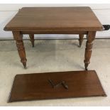 A vintage oak winding draw leaf dining table with turned legs on ceramic castors.