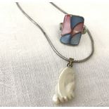 A mother of pearl foot shaped pendant on a silver rope chain.