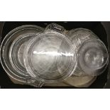 A box of assorted patterned clear glass serving plates and dishes.