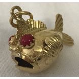A 18ct gold fish charm with coral set eyes.