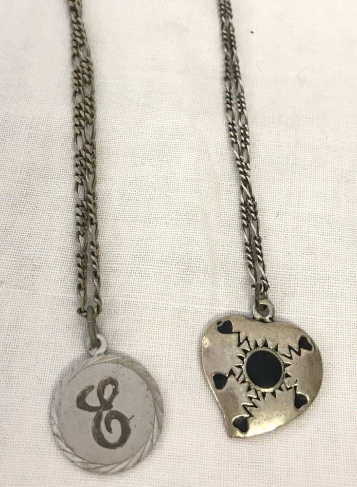 Two 18 inch silver figaro chains with pendants.