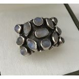 A silver dress ring set with 13 round, oval and marquise cut cabochon moonstones.