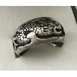 A men's silver band ring decorated with a oriental dragon.