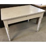 A Victorian Pine farmhouse kitchen table painted white.