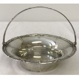 A hallmarked silver circular shaped, hinged handled basket with cross design to rim and handle.