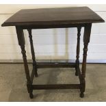A vintage dark oak occasional table with turned detail to legs.