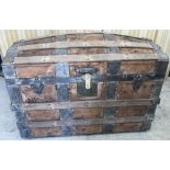 A vintage barrel top wooden travellers trunk with both wood and metal banding.