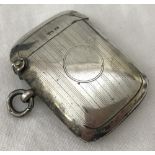 A silver vesta case with empty cartouche and engine turned decoration.