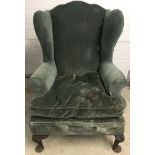 A vintage wing back arm chair with shaped top.