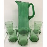 A vintage green glass jug together with 5 matching glasses (1 a/f).