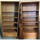 A pair of vintage teak shelving units with 2 drawers to base.