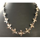 A decorative flower link silver necklace. Approx. 16 inches long.