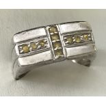 A men's silver ring set with 10 yellow stones to top in cross design.