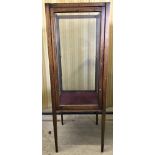 A vintage dark wood and glass display cabinet on tapered legs.