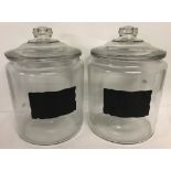 2 large glass lidded confectionary jars with blank labels to front.