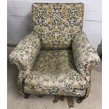 A Victorian armchair with wooden legs and ceramic castors.