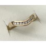 A 9ct gold wishbone style wedding/eternity ring with 0.15 ct channel set diamonds.