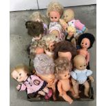 A box of vintage medium and small vinyl dolls.
