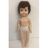 A 1950's hard plastic "Roddy" walker doll with no clothes.