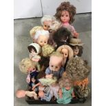 A box of vintage small and medium vinyl dolls.