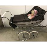 A 1970's Silver Cross dolls pram complete with cover and changing bag.