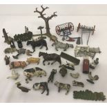 A tin of vintage Britains lead farm figures and machinery.