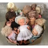 A box of vintage large and medium vinyl dolls.