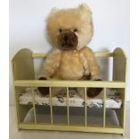 A 1950's Blonde Schuco nursery bear together with a vintage wooden toy dolls cot.