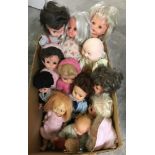 A box of medium and small vintage vinyl dolls.