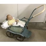 A vintage rear facing pushchair with vintage vinyl doll.