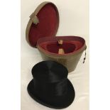 A vintage Top Hat in a red velvet lined leather carrying case.