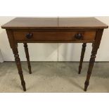 A vintage oak side hall table with central draw supported by turned legs.