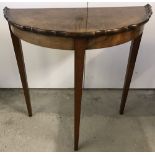A vintage half moon hall table with piecrust edge to top, on tapered legs.