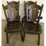 A set of four solid dark oak dining chairs with leatherette seats.