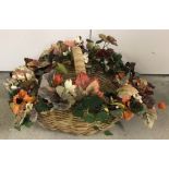 A large handled basket with autumnal artificial flower spray surround.