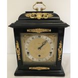 A reproduction wooden cased Elliott of London mantle clock with brass detail.