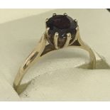A 9ct gold high set garnet solitaire dress/engagement ring.