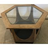 A vintage wooden framed hexagonal coffee table with glass insert top.