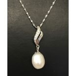 A 925 silver pendant with decorative bale set with small white stones and a freshwater pearl drop.
