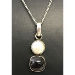 A 925 silver drop pendant set with a freshwater pearl and a square cut cabochon garnet.