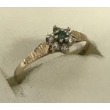 A 9ct gold small flower design emerald and diamond dress ring.