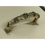 A 9ct gold emerald and diamond half eternity ring.